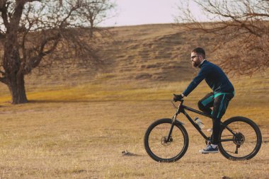 Bisikletçi sonbahar ormanlarında gezer ve park eder.