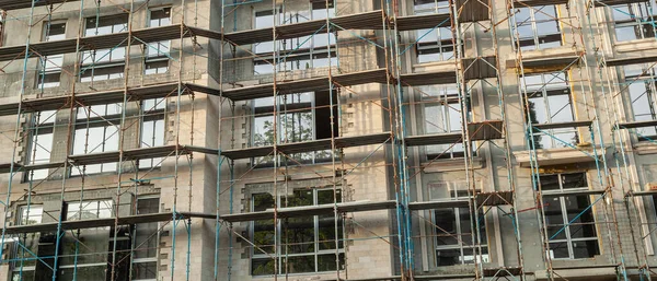 Mavi gökyüzünün arka planında inşaat halindeki çok katlı bir bina ve vinç manzarası