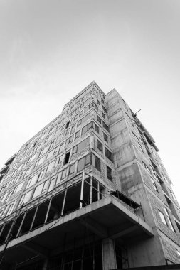 Mavi gökyüzünün arka planında yapım aşamasında olan çok katlı bir binanın siyah beyaz fotoğrafı.