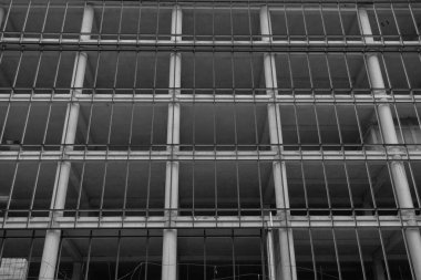 Mavi gökyüzünün arka planında yapım aşamasında olan çok katlı bir binanın siyah beyaz fotoğrafı.