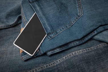 Kot pantolonda beyaz cep telefonu