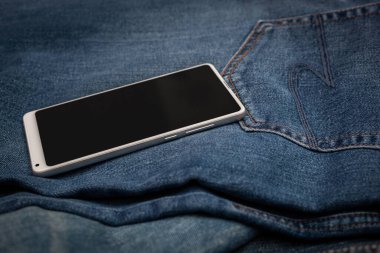 Kot pantolonda beyaz cep telefonu
