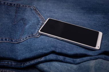 Kot pantolonda beyaz cep telefonu
