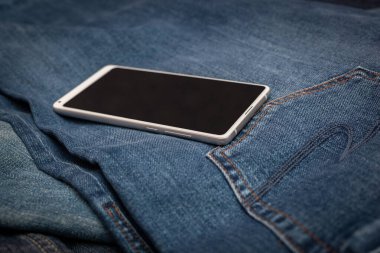 Kot pantolonda beyaz cep telefonu