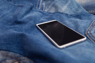 Kot pantolonda beyaz cep telefonu