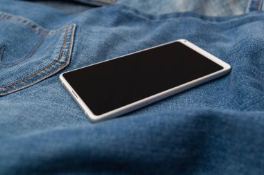 Kot pantolonda beyaz cep telefonu