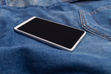 Kot pantolonda beyaz cep telefonu