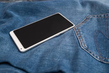Kot pantolonda beyaz cep telefonu