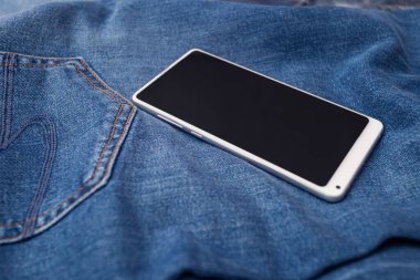 Kot pantolonda beyaz cep telefonu