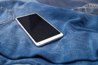Kot pantolonda beyaz cep telefonu