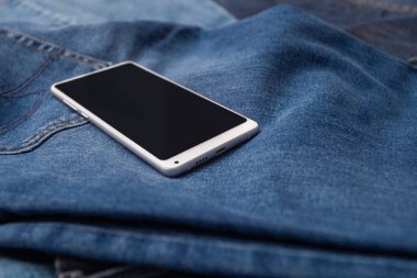 Kot pantolonda beyaz cep telefonu
