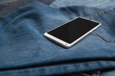 Kot pantolonda beyaz cep telefonu