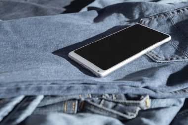 Kot pantolonda beyaz cep telefonu