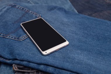 Kot pantolonda beyaz cep telefonu