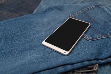 Kot pantolonda beyaz cep telefonu