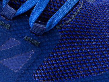 Çizgili makro iplikli mavi bir spor ayakkabısının parçası.