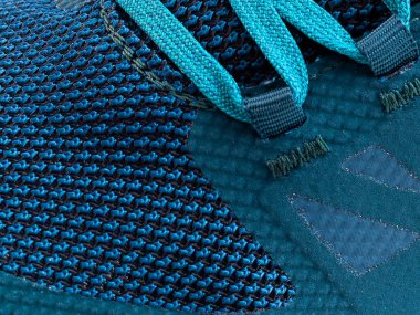 Çizgili makro iplikli mavi bir spor ayakkabısının parçası.