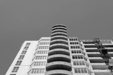 Mavi gökyüzünün arka planında yapım aşamasında olan çok katlı bir binanın siyah beyaz fotoğrafı.