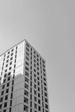 Mavi gökyüzünün arka planında yapım aşamasında olan çok katlı bir binanın siyah beyaz fotoğrafı.