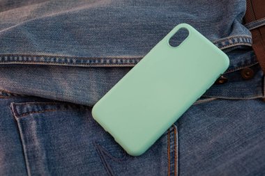 kot pantolon arka planında çok renkli cep telefonu kılıfı