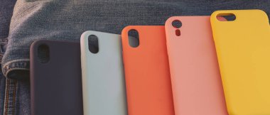 kot pantolon arka planında çok renkli cep telefonu kılıfı