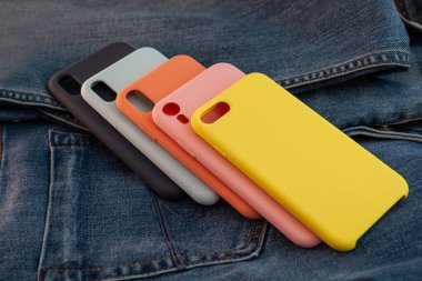 kot pantolon arka planında çok renkli cep telefonu kılıfı