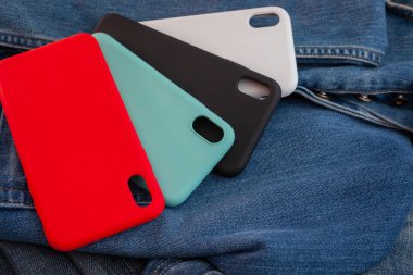 kot pantolon arka planında çok renkli cep telefonu kılıfı