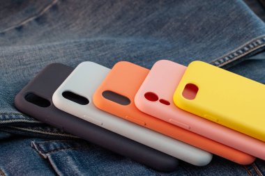 kot pantolon arka planında çok renkli cep telefonu kılıfı