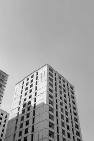 Černobílá Fotografie Vícepodlažní Obytné Budovy Výstavbě Jeřábu Pozadí Modré Oblohy — Stock fotografie
