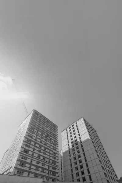 蓝天背景下在建多层住宅及起重机的黑白照片 — 图库照片