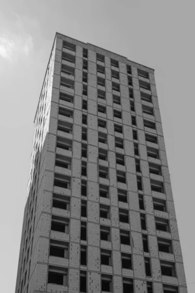Černobílá Fotografie Vícepodlažní Obytné Budovy Výstavbě Jeřábu Pozadí Modré Oblohy — Stock fotografie