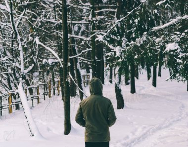 Genç adam kış ormanında