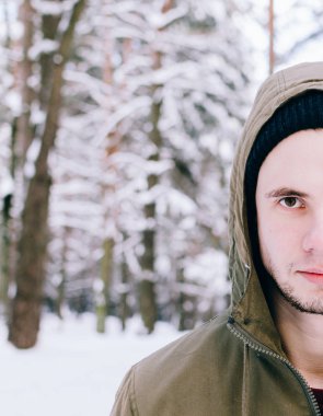 Genç adam kış ormanında