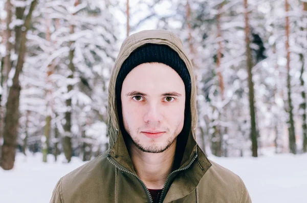 Genç adam kış ormanında