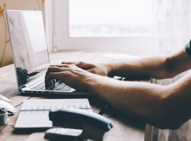 Dizüstü bilgisayarda çalışan adam