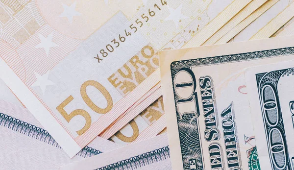 Euro y dólares en la mesa — Foto de Stock