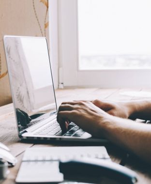 Dizüstü bilgisayarda çalışan adam