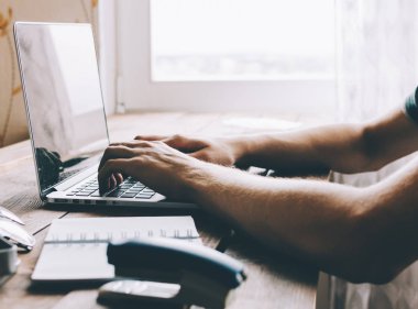 Dizüstü bilgisayarda çalışan adam