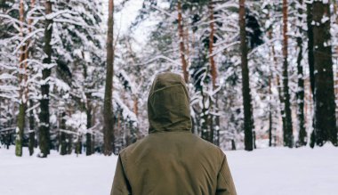 Genç adam kış ormanında