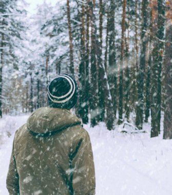 Genç adam kış ormanında