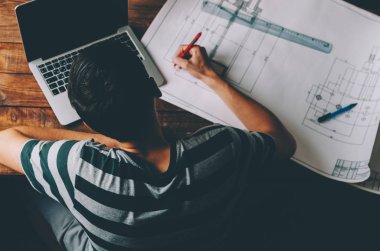 Bir inşaat projesini çizen mimar 