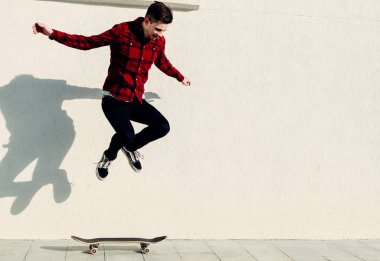 Genç adam kaykaya biniyor. 