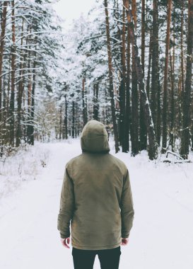 Genç adam kış ormanında