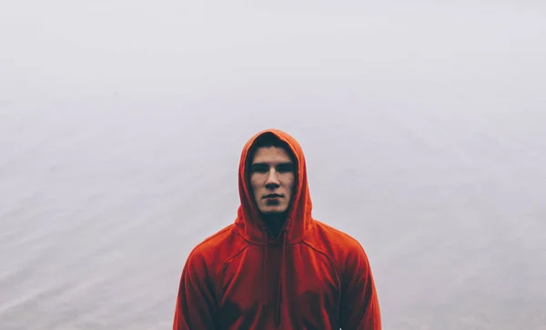 Homme en sweat à capuche par le lac — Photo