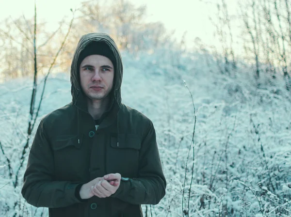 Young man in winter forest