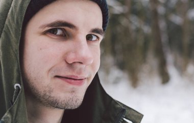 Genç adam kış ormanında