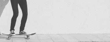 Genç adam kaykaya biniyor. 