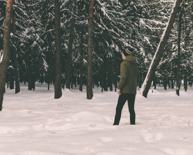 Genç adam kış ormanında