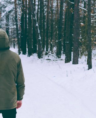 Genç adam kış ormanında