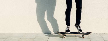 Genç adam kaykaya biniyor. 